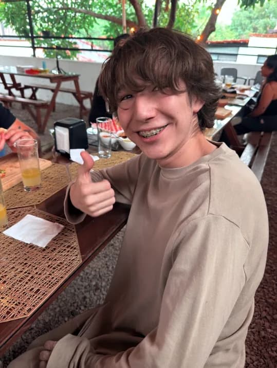 Joven sonriendo durante una comida en la terraza