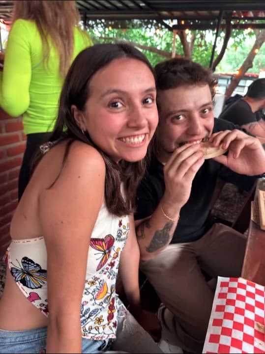 Dos comensales compartiendo una hamburguesa y una sonrisa